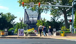 Pedestrians on bridge with red light in foreground